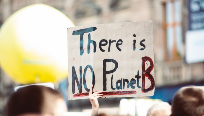 Person holding a paper written There is No Planet B in red lettering