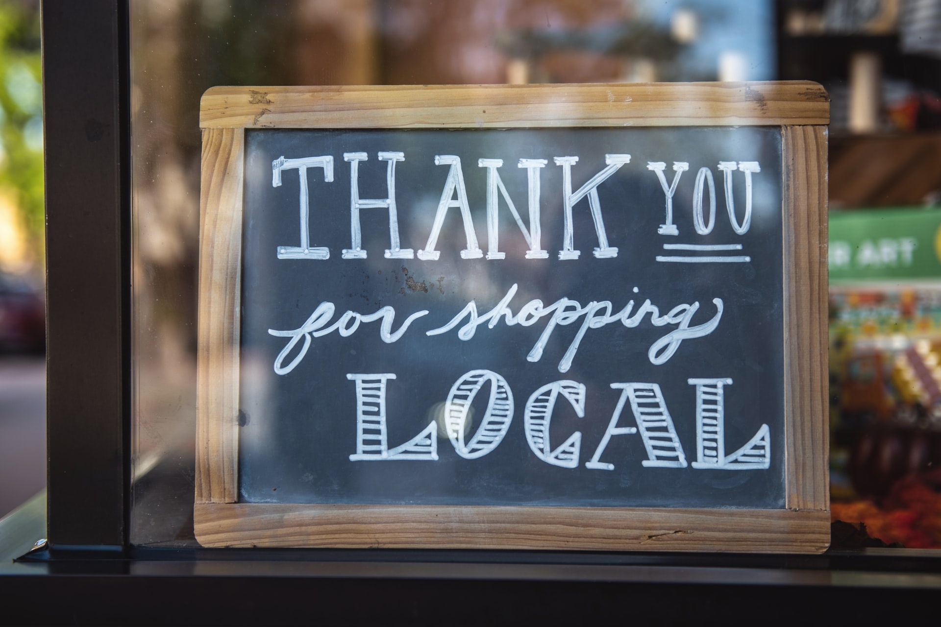 Store sign with the message Thank you for shopping local written on it