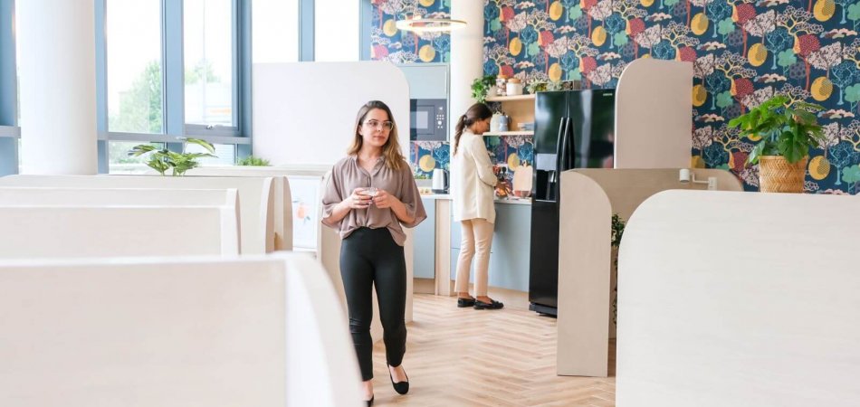 Two woman standing in a coworking space room