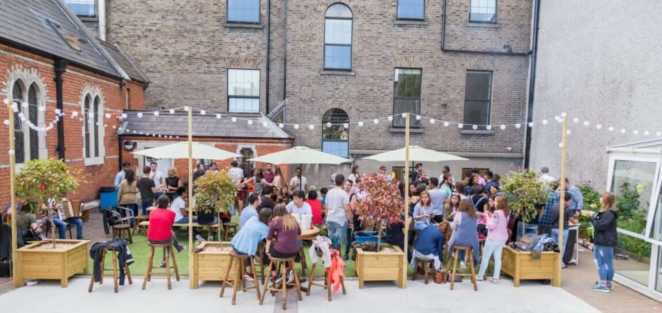 Gardiner House Hostel terrace People sitting in outdoor garden enjoying a party