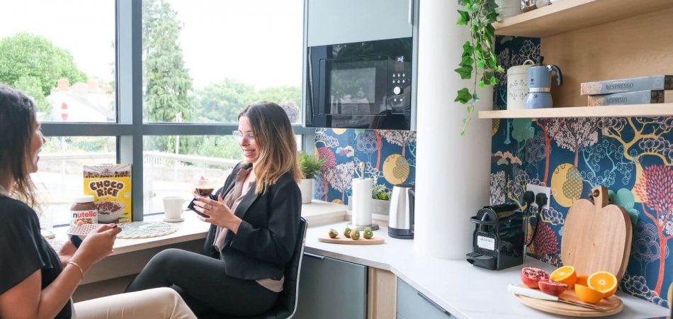 Canbe Coworking, Inchicore, Dublin Two woman sitting in a kitchenette facility, drinking coffee and chatting